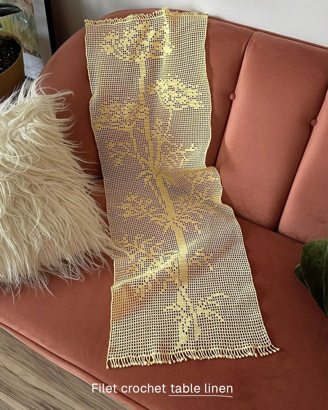 Yellow filet-crochet table linen on a coral velvet sofa